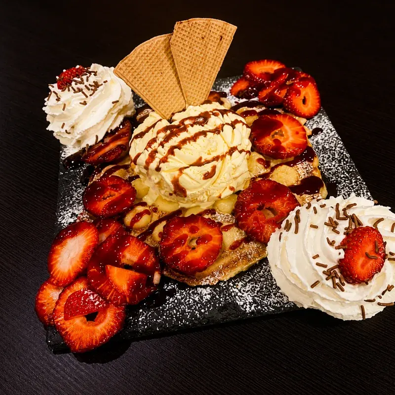 Gaufre garnie de glace, chantilly, fraises et gaufrettes